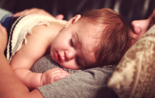 a sick baby lies in her mother's arms